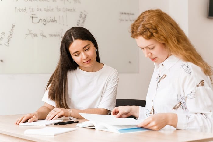 teacher english asks student white class 2 girls student answers teacher